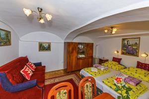 une chambre d'hôtel avec deux lits et un canapé dans l'établissement Barokk Vendégház, à Eger