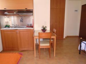 a small kitchen with a table and a sink at Finikes Studios in Oreoi