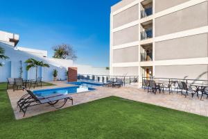 a patio with tables and chairs next to a building at Bristol Zaniboni Mogi Mirim in Mogi Mirim