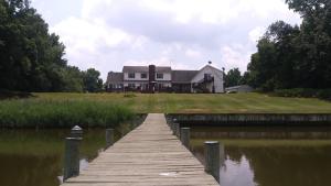 una casa en el agua con un muelle de madera en Marvels on the creek, en East New Market