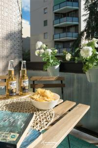 una mesa con un tazón de comida y dos botellas de cerveza en Oki Doki Studios en Milán
