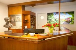 a lobby with a desk with a vase of flowers at Classic Hotel Kaarst in Kaarst