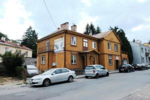 drewniany dom z dwoma samochodami zaparkowanymi przed nim w obiekcie Apartament Mieszczański w mieście Sandomierz