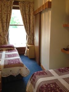 a hotel room with two beds and a window at Ballyglass Country House in Tipperary