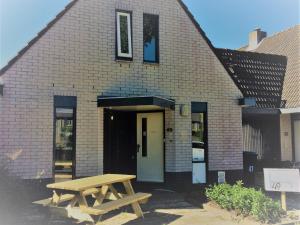 een houten picknicktafel voor een bakstenen gebouw bij Haarlem 49 in Haarlem