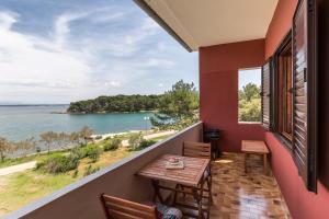 a balcony with a table and a view of the water at Apartmani Bruno in Ugljan