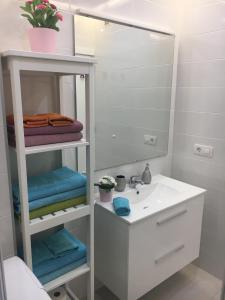 a white bathroom with a sink and a mirror at Amazing View in Los Cristianos in Los Cristianos