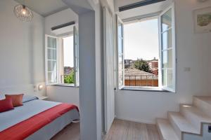 西恩納的住宿－La Barriera di San Lorenzo - Dimora Storica，一间卧室设有一张床和两个窗户。