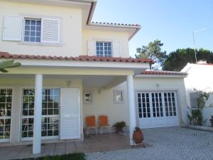 a white house with orange chairs in front of it at Moradia da Bananeira in Lagoa de Albufeira
