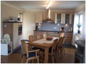 cocina con mesa de madera y sillas en una habitación en Ferienhaus "et Eifelparadiesje", en Gerolstein