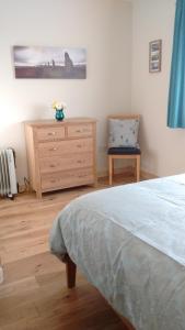 1 dormitorio con 1 cama, vestidor y silla en Fara 2 room, 1 bedroom - B&B private suite en Kirkwall