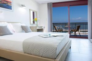 ein Schlafzimmer mit einem Bett mit Blick auf das Meer in der Unterkunft Excess Pansion in Lefkada Town