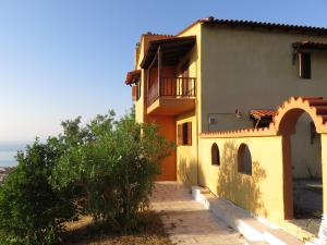 a house with a balcony and a tree at Best view in Polychrono - Families Only in Polychrono