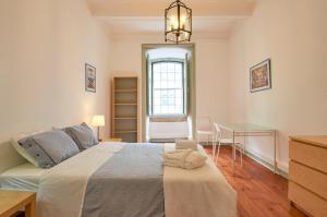 1 dormitorio con cama, escritorio y ventana en Palácio SantAnna, en Lisboa