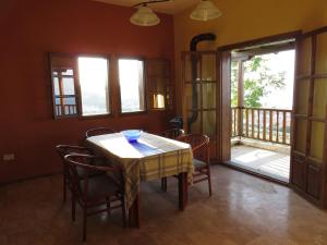 a dining room with a table and chairs and a balcony at Best view in Polychrono - Families Only in Polychrono