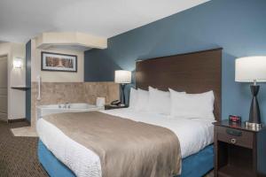 A bed or beds in a room at AmericInn by Wyndham Windom