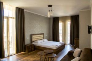 a bedroom with a bed and a couch at Hotel Absolut in Batumi