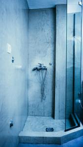 La salle de bains est pourvue d'une douche avec une porte en verre. dans l'établissement Violet City Center Apartments, à Kavala