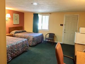 
a hotel room with two beds and a television at Elmwood Motor Lodge in Boscawen
