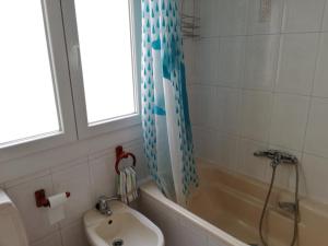 ein Bad mit einer Badewanne, einem Waschbecken und einer Dusche in der Unterkunft Apartamento Santa Marta in Santiago de Compostela