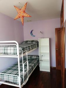 2 literas en una habitación con una estrella en el techo en Apartamento Santa Marta, en Santiago de Compostela