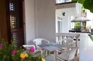 una mesa y sillas en un patio con flores en Apartman Linera en Soko Banja