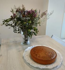 un pastel en un plato en una mesa con un jarrón de flores en Tudela balcón de Bardenas, en Tudela