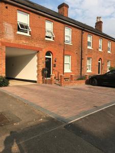 a brick building with a garage and a parking lot at Berkshire Serviced Apartment Helena 12 in Reading