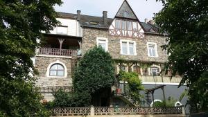 a large brick building with a balcony on it at 'Ferienhaus Mosel' mit kostenfreien ÖPNV-Ticket in Ürzig
