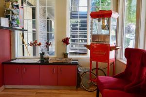 una cocina con armarios rojos y una silla roja en Village Inn, en Springfield