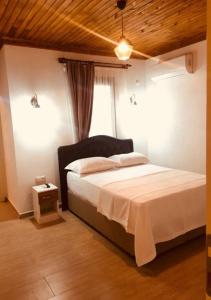 1 dormitorio con 1 cama blanca y ventana en Aydeniz Otel, en Mesudiye