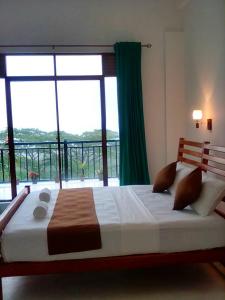 a bedroom with a large bed with a large window at HIDE IN HANTANA The best place to hide in Kandy in Kandy