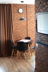 een eetkamer met een tafel en stoelen en een bakstenen muur bij Apartment near Megacenter in Chernihiv