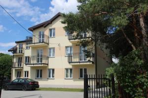 a building with balconies and a car parked in front at Fredry 8 in Piastów