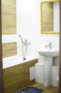 W łazience znajduje się umywalka oraz wanna z lustrem. w obiekcie Apartment near Megacenter w mieście Czernihów