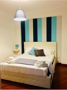 a bedroom with a bed with a striped wall at Giupy Home in Catania