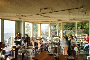 a group of people sitting at tables in a restaurant at Hotel & Cafe Veliche in Castro