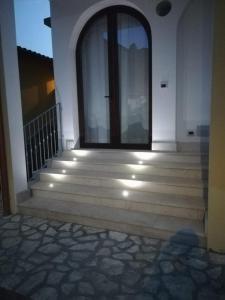 eine Eingangstür eines Hauses mit Treppen und Lichtern in der Unterkunft Sa Caladroxa in Villa San Pietro