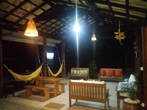 un patio con bancos y hamacas en un edificio en Nalu Guest House en Ubatuba