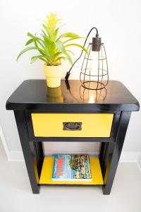 a black and yellow console table with a plant at Pinehill Rooms in Reading