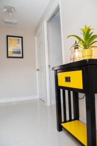 uma mesa de consola preta e amarela com uma planta sobre ela em Pinehill Rooms em Reading
