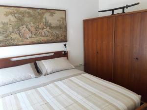 a bedroom with a bed and a painting on the wall at Appartamento MiMa Pineta in Milano Marittima