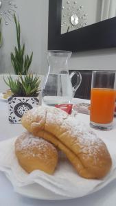 two pastries on a plate next to a glass of orange juice at B&B Inn Centro in Cosenza