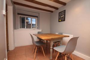 uma sala de jantar com uma mesa de madeira e cadeiras em Malvern House em Banbury