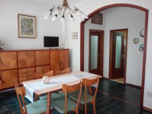 a dining room with a table and chairs and a television at Appartamento MiMa Pineta in Milano Marittima