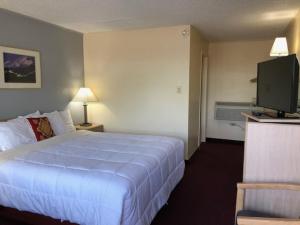 a hotel room with a bed and a flat screen tv at A1 Choice Inn in Mount Shasta