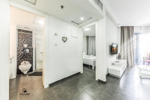 a white bathroom with a toilet and a sink at Turists Vacation Sea of Galilee in Tiberias