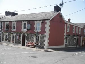 a red building on the corner of a street at Fitzpatrick's Tavern and Hotel in Cavan