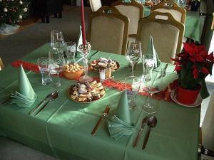 een tafel met een groene tafelkleed met voedsel- en wijnglazen bij Sporthotel Rudolf in Boží Dar