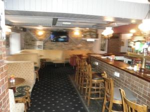 キャバンにあるFitzpatrick's Tavern and Hotelの木製のテーブルと椅子のあるバー付きのレストラン